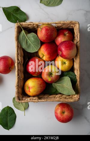 Wenige rote Äpfel in der Kiste auf Lebensmitteln mit leichter Oberfläche Stockfoto