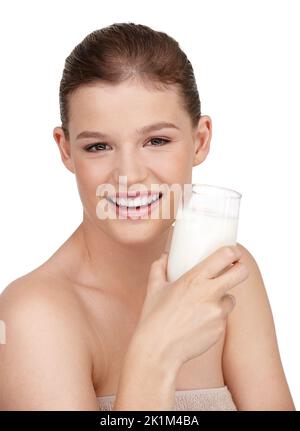 Milkt am besten für starke Knochen. Ein lächelndes Teenager-Mädchen, das ein Glas Milch in der Hand hält. Stockfoto