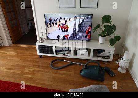 Jemand, der eine Fernsehsendung des schwedischen Fernsehens verfolgt, als der Sarg von Königin Elizabeth II. In Westminster Abbey, London, Großbritannien, getragen wird. Stockfoto