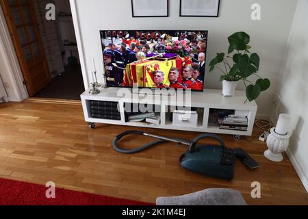 Jemand, der eine Fernsehsendung des schwedischen Fernsehens verfolgt, als der Sarg von Königin Elizabeth II. In Westminster Abbey, London, Großbritannien, getragen wird. Stockfoto