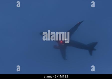 Schlechtes Wetter, Luftfahrt, Transport, Reisekonzept. Großkörperflugzeug starten bei niedrigen Wolken, schlechter Sicht und nebligen Temperaturen bei kaltem Wetter Stockfoto