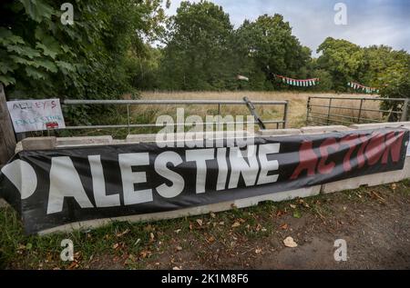 Shenstone, Großbritannien. 18. September 2022. Gegenüber der Fabrik hängt ein Palestine Action Banner und palästinensische Fahnen hängen im Wald dahinter. UAV Engines ist eine Tochtergesellschaft des israelischen Verteidigungsunternehmens Elbit Systems und produziert Motoren für Drohnen, die gegen Palästinenser in Gaza und anderswo eingesetzt werden. Die Demonstranten fordern die Schließung der Fabrik. Palästinensische Aktionisten protestieren gegen die Präsenz von Elbit Systems im Vereinigten Königreich. Ihre ständigen Aktionen haben zwei der zehn Fabriken von Elbit Systems geschlossen. Kredit: SOPA Images Limited/Alamy Live Nachrichten Stockfoto