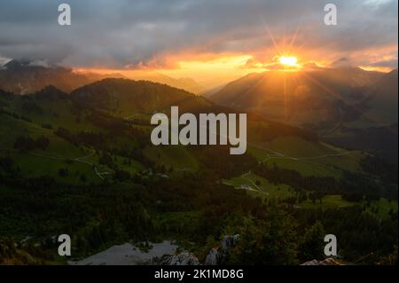 sunstar bei Sonnenuntergang über den Ausläufern von Gruyeres in Freiburg Stockfoto