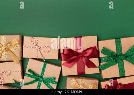 Eingewickelte Geschenke mit Bändern auf grünem Hintergrund. Boxtag-Konzept mit Platz für Text. Stockfoto