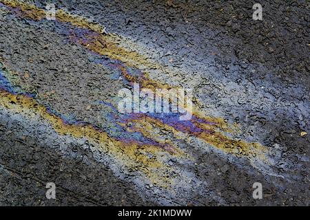 Ökologisches Problem, bunter Ölfleck auf einer nassen Asphaltstraße Stockfoto