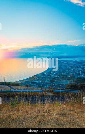 Atemberaubender Blick auf den Sonnenuntergang über dem chesil Beach auf der Isle of Portland an der Jurassic Coast von Dorset mit Blick zurück nach Weymouth Stockfoto