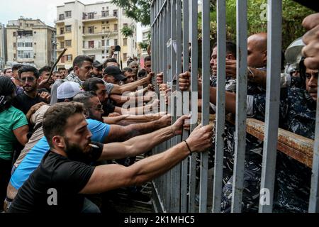 Beirut, Libanon. 19. September 2022. Libanesische Aktivisten nehmen das Tor des Justizpalastes während eines Protestes, in dem sie die Freilassung von zwei Personen forderten, die festgenommen wurden, nachdem sie letzte Woche eine lokale Bank mit einer Pistole stürmten, um einem Einleger dabei zu helfen, ihre Ersparnisse einzutreiben. Libanesische Banken haben die meisten Einleger aufgrund des wirtschaftlichen Zusammenbruchs des Landes aus ihren Ersparnissen ausgeschlossen. Quelle: Marwan Naamani/dpa/Alamy Live News Stockfoto