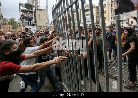 Beirut, Libanon. 19. September 2022. Libanesische Aktivisten nehmen das Tor des Justizpalastes während eines Protestes, in dem sie die Freilassung von zwei Personen forderten, die festgenommen wurden, nachdem sie letzte Woche eine lokale Bank mit einer Pistole stürmten, um einem Einleger dabei zu helfen, ihre Ersparnisse einzutreiben. Libanesische Banken haben die meisten Einleger aufgrund des wirtschaftlichen Zusammenbruchs des Landes aus ihren Ersparnissen ausgeschlossen. Quelle: Marwan Naamani/dpa/Alamy Live News Stockfoto