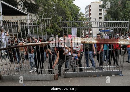 Beirut, Libanon. 19. September 2022. Libanesische Aktivisten nehmen das Tor des Justizpalastes während eines Protestes, in dem sie die Freilassung von zwei Personen forderten, die festgenommen wurden, nachdem sie letzte Woche eine lokale Bank mit einer Pistole stürmten, um einem Einleger dabei zu helfen, ihre Ersparnisse einzutreiben. Libanesische Banken haben die meisten Einleger aufgrund des wirtschaftlichen Zusammenbruchs des Landes aus ihren Ersparnissen ausgeschlossen. Quelle: Marwan Naamani/dpa/Alamy Live News Stockfoto