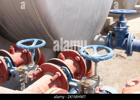 Riesige Industrierohre mit Hahn-Vorratsbehälter für Flüssigkeiten. Der Fluss von Flüssigkeiten oder Gas. Nahaufnahme Stockfoto