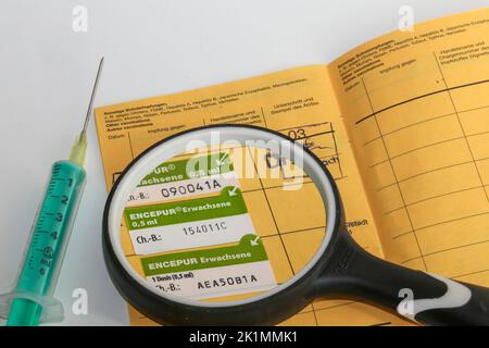 Symbolbild Zeckenimpung: Aufgeschlagenes gelbes Impfbuch mit einem neuen Eintrag für eine Zeckenimpung Stockfoto