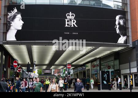 Market Street Manchester. Elektronisches Display, das die junge und alte Königin Elizabeth II. Zeigt Eva der Beerdigung des Monarchen. Stockfoto