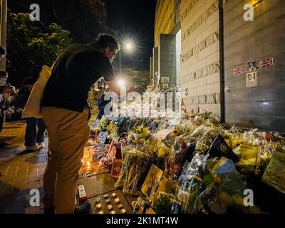 Hongkong, China. 19. September 2022. Trauernde legen Blumen vor das britische Generalkonsulat Hongkong. Die Massen in Hongkong schlangen in der Hitze vor dem britischen Generalkonsulat in Hongkong an, um der britischen Königin Elizabeth II. Am Tag ihrer Beerdigung Tribut zu zollen. Die Menschen brachten Blumen und zündeten Kerzen über die Straßen an. (Foto von Dominic Chiu/SOPA Images/Sipa USA) Quelle: SIPA USA/Alamy Live News Stockfoto