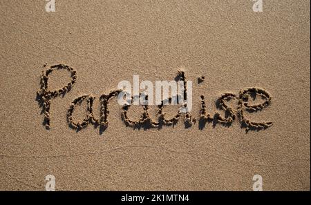 Das Wort 'Paradies', das in den Sand an einem Strand in Zypern geschrieben ist Stockfoto