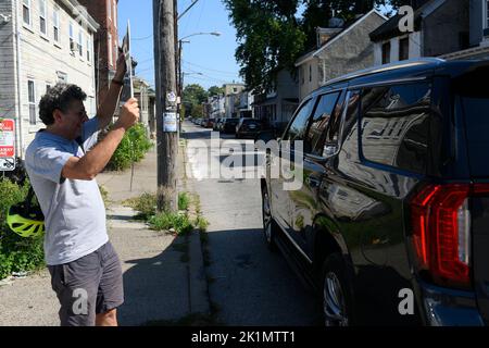 Philadelphia, Usa. 19. September 2022. Demonstranten demonstrieren, wie ein Fahrzeug, das vermutlich den republikanischen Senatskandidaten Dr. Mehmet Oz trägt, am 19. September 2022 durch einen Hintereingang eine Veranstaltung zur gemeinsamen Diskussion der sicheren Straßen im Stadtteil Germantown im Nordwesten von Philadelphia, PA, USA, durchläuft. Kredit: OOgImages/Alamy Live Nachrichten Stockfoto