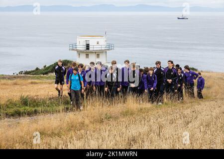 Kinder und Lehrer der Gordonstoun Schule markieren die staatliche Beerdigung von Königin Elizabeth II. Beim Spaziergang zum Wachturm der Küstenwache im nahe gelegenen Covesea, der 1955 von Prinz Philip eröffnet wurde und von König Karl III. Während seiner Zeit als Kapitän des Küstenwache-Dienstes in Gordonstoun genutzt wurde. Bilddatum: Montag, 19. September 2022. Stockfoto