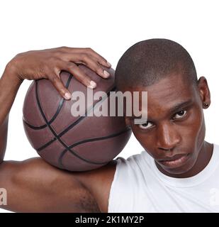 Bereit für ein Spiel. Studio-Porträt eines jungen Basketballspielers, der mit seinem Basketball steht. Stockfoto