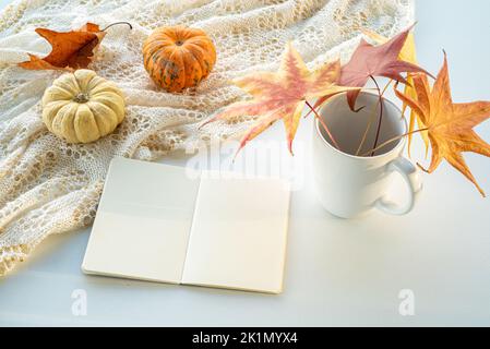 Herbstkomposition. Leerer Kalender, Notebook-Modell auf weißem Hintergrund. Kürbisse, trockene Blätter. Herbst, Herbst, halloween Konzept Stockfoto