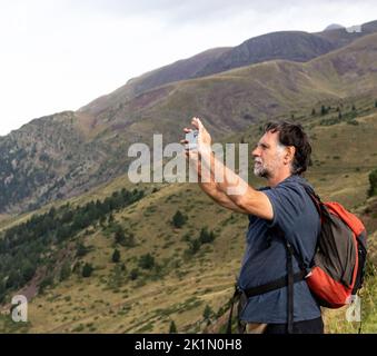 Älterer Mann, der Selfie auf dem Berg gemacht hat Stockfoto