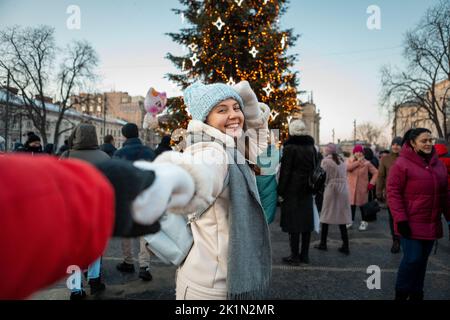 Folgen Sie mir Konzept Frau zieht Mann zum weihnachtsbaum Stockfoto