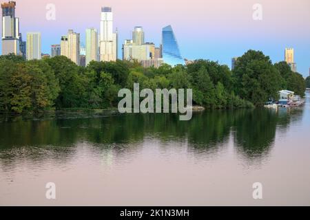 Skyline von Austin TX in der Abenddämmerung Blick von der Brücke über den Colorado River auf den Ann und Roy Butler Hike und Bike Trail und Boardwalk am Lady Bird Lake Stockfoto