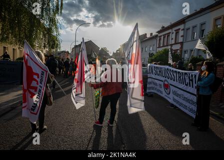 Saarlouis, Deutschland. 19. September 2022. Die Teilnehmer stehen an der Gedenkkundgebung für Samuel Yeboah, einen ghanaischen Asylbewerber, der 1991 bei einem Brandanschlag getötet wurde. Mitte November beginnt der Prozess gegen einen 51-jährigen Mann vor dem Oberlandesgericht Koblenz - unter anderem wegen Mordes. Er soll in der Nacht vom 18. Auf den 19. September 1991 das Feuer in der Unterkunft der Asylbewerber angezündet haben. Quelle: Harald Tittel/dpa/Alamy Live News Stockfoto