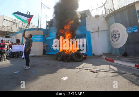 Gaza, Palästina. 19. September 2022. Ein Protestler hält eine palästinensische Flagge während einer Demonstration vor dem Hauptquartier des UN-Hilfswerks für palästinensische Flüchtlinge. Palästinensische Gruppen organisierten einen Protest gegen das Werk- und Hilfswerk der Vereinten Nationen (UNRWA) und forderten, dass das UNRWA die palästinensischen Häuser wiederaufbauen sollte, die während der Kämpfe zwischen Israel und Gaza im Jahr 2014 zerstört wurden. (Foto von Ahmed Zakot/SOPA Images/Sipa USA) Quelle: SIPA USA/Alamy Live News Stockfoto