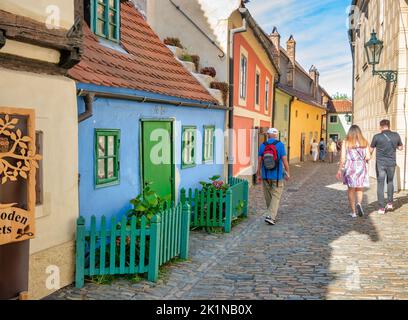 Prag, Tschechische Republik - Juni 2022: Touristen schlendern auf der berühmten Straße Golden Lane in der Prager Burg. Stockfoto