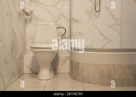 Toilettenschüssel und Duschkabine in einer Wohnwohnung in der Ukraine in hellen Farben, Bad, Interieur Stockfoto