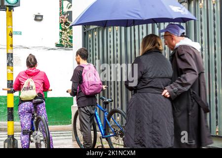 Bogota Kolumbien,Carrera 24,Teenager Teenager Teenager Teenager Teenager Jugendliche Jugend Fahrrad Fahrräder Fahrrad fahren Fahrräder,Wandern Regenschirm Mann Männer männlich Frau Frauen weiblich Stockfoto