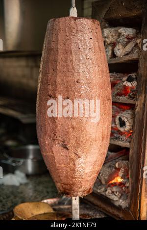 Küchenchef schneidet traditionelle türkische Gerichte Shawarma Fleischspender Kebab im Restaurant im Freien. , Türkischer Kebab-iskender-Döner Stockfoto