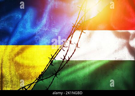 Grunge Flaggen der Ukraine und Ungarn geteilt durch Stacheldraht Illustration Sonne Dunst Ansicht, Konzept der angespannten Beziehungen zwischen zwei Ländern Stockfoto