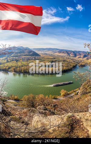 Österreichische Flagge und Panorama der Wachau mit Schiff auf der Donau im Herbst in Österreich, UNESCO Stockfoto