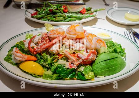 Selektiver Fokus auf Seafood Salatplatte mit Krabben, Garnelen und Hummer sowie Avocado und Zitronenkeil Stockfoto