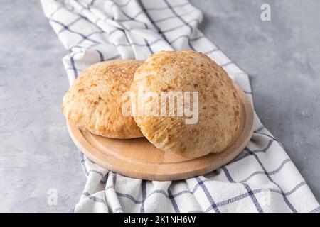 Pitabrot auf neutralem Hintergrund. Arabisches, libanesisches Brot, traditionelles Essen Stockfoto