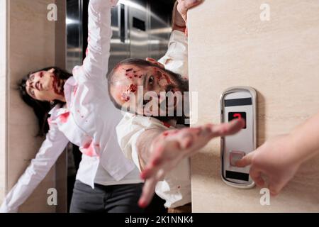 Porträt eines Mannes Zombie Angriff Büro, Flucht Aufzug und sieht gefährlich mit blutigen Narben. Unheimliche, aggressive Monster, die erschreckend sind und Menschen nachjagen, Gehirn-fressende Wanderer. Stockfoto