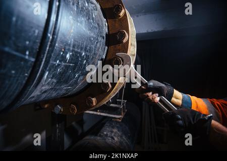 Arbeiter, der Wasserleitung im technischen Tunnel installiert, Nahaufnahme Stockfoto