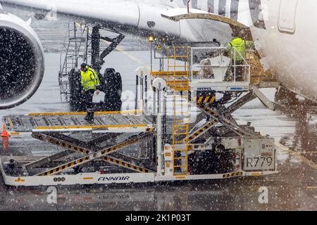 HELSINKI, FNLAND, 15 2022. FEBRUAR, Verladen eines Flugzeugs vor dem Abflug am Flughafen bei Schneefall Stockfoto