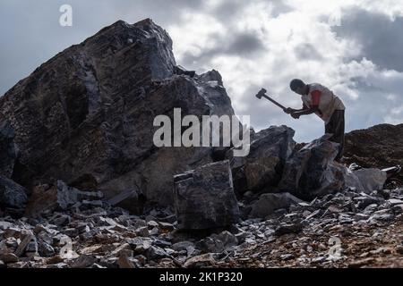 Südkonawe, Indonesien. 19. September 2022. Ein Steinminer bricht einen Stein, der in kleinere Stücke verbrannt wurde. Traditioneller Steinabbau, der von den Bewohnern des Dorfes Sanggula durchgeführt wird. Traditionelle Bergleute, die übrigens Anwohner sind, verkaufen ihre Arbeit in der Regel an Bergbauunternehmen. Kredit: SOPA Images Limited/Alamy Live Nachrichten Stockfoto