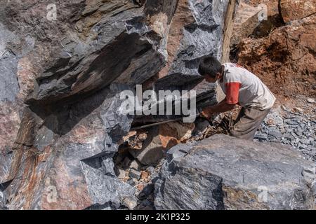 Südkonawe, Indonesien. 19. September 2022. Ein Steinminer nimmt einen verbrannten Stein auf. Traditioneller Steinabbau, der von den Bewohnern des Dorfes Sanggula durchgeführt wird. Traditionelle Bergleute, die übrigens Anwohner sind, verkaufen ihre Arbeit in der Regel an Bergbauunternehmen. Kredit: SOPA Images Limited/Alamy Live Nachrichten Stockfoto