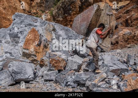 Südkonawe, Indonesien. 19. September 2022. Ein Steinminer bricht einen riesigen Stein, der in kleine Stücke verbrannt wurde. Traditioneller Steinabbau, der von den Bewohnern des Dorfes Sanggula durchgeführt wird. Traditionelle Bergleute, die übrigens Anwohner sind, verkaufen ihre Arbeit in der Regel an Bergbauunternehmen. Kredit: SOPA Images Limited/Alamy Live Nachrichten Stockfoto