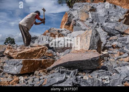 Südkonawe, Indonesien. 19. September 2022. Ein Steinminer bricht einen riesigen Stein, der in kleine Stücke verbrannt wurde. Traditioneller Steinabbau, der von den Bewohnern des Dorfes Sanggula durchgeführt wird. Traditionelle Bergleute, die übrigens Anwohner sind, verkaufen ihre Arbeit in der Regel an Bergbauunternehmen. (Foto von Andry Denisah/SOPA Images/Sipa USA) Quelle: SIPA USA/Alamy Live News Stockfoto