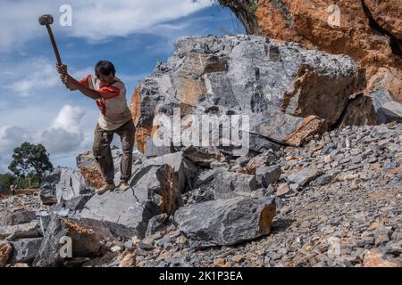 Südkonawe, Indonesien. 19. September 2022. Ein Steinminer bricht einen riesigen Stein, der in kleine Stücke verbrannt wurde. Traditioneller Steinabbau, der von den Bewohnern des Dorfes Sanggula durchgeführt wird. Traditionelle Bergleute, die übrigens Anwohner sind, verkaufen ihre Arbeit in der Regel an Bergbauunternehmen. (Foto von Andry Denisah/SOPA Images/Sipa USA) Quelle: SIPA USA/Alamy Live News Stockfoto