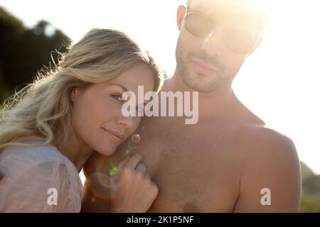 Immer so nah dran. Kopf- und Schulterporträt einer attraktiven jungen Frau, die ihren Mann an einem sonnigen Tag umarmt. Stockfoto