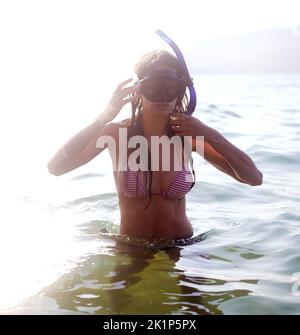 Eine junge Frau, die eine Schwimmbrille im Wasser trägt. Stockfoto