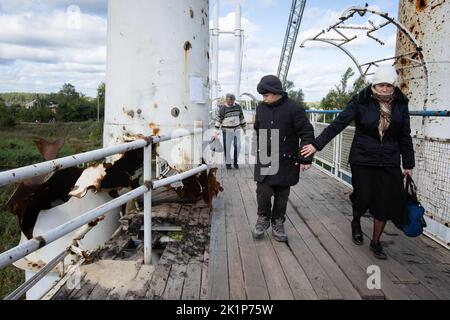 Izium, Ukraine. 19. September 2022. Die Anwohner gehen entlang der zerstörten Brücke über den Fluss Siversky Donez in der Stadt Izium, die kürzlich von den ukrainischen Streitkräften befreit wurde, im Gebiet Charkiw. Die Stadt Izium wurde am 1. April 2022 von russischen Truppen besetzt. Kredit: SOPA Images Limited/Alamy Live Nachrichten Stockfoto