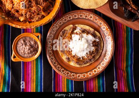 Tostada de Tinga de Res. Typisch mexikanisches Gericht, das hauptsächlich mit geschreddertem Rindfleisch, Zwiebeln und getrockneten Chilischoten zubereitet wird. Es ist üblich, es auf Mais-Tortill zu servieren Stockfoto