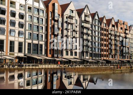 Moderne Gebäude über dem Fluss Motlawa in der Altstadt. Abstrakte Struktur. Kreatives Foto Tourismus auf dem Motlawa River. Neue Apartments-Architektur auf Granary Island Glasfenster mit Reflexionen. Touristisches Reiseziel Stockfoto