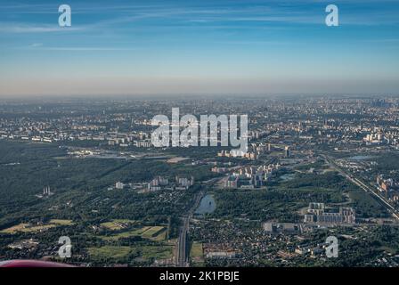 Luftbild Foto aus dem Flugzeug der Stadt und klaren Himmel. Luftaufnahmen der großen Stadt aus einem Flugzeugfenster. Blick auf die moderne Stadt aus Flugzeug gewinnen Stockfoto