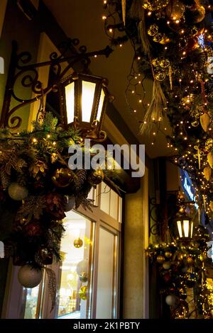 Weihnachtsschmuck und ein Weihnachtsbaum in den Fenstern der Geschäfte der Stadt, in der Nacht. Tolle Weihnachten Hintergrund Stockfoto